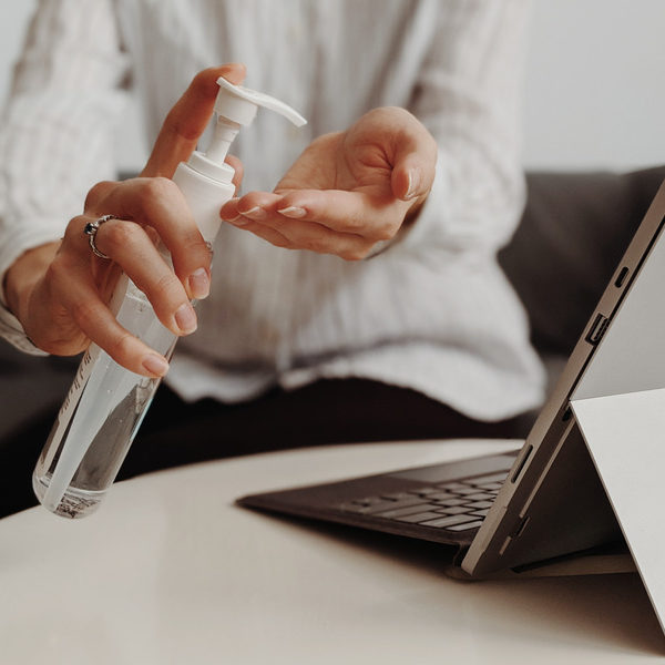 Canva - Woman using hand sanitizer at work